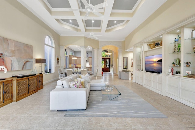 living room featuring built in shelves, ceiling fan, decorative columns, a high ceiling, and coffered ceiling