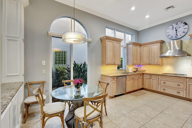 kitchen with visible vents, light brown cabinets, a sink, appliances with stainless steel finishes, and wall chimney range hood