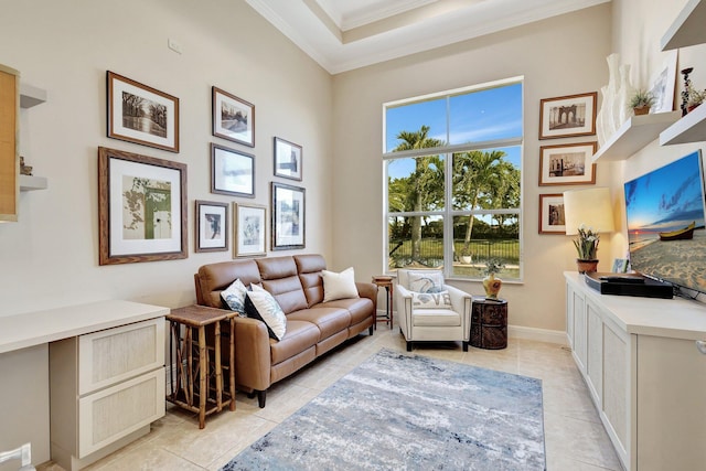 living room featuring crown molding, light tile patterned floors, baseboards, and a tray ceiling