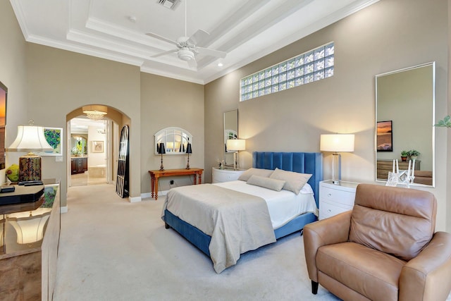 bedroom with visible vents, carpet floors, a tray ceiling, arched walkways, and crown molding