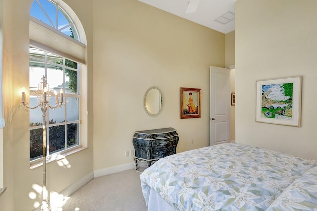 bedroom with visible vents, carpet floors, an inviting chandelier, baseboards, and a towering ceiling