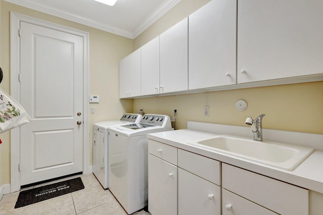 laundry room featuring light tile patterned floors, cabinet space, a sink, crown molding, and washer and clothes dryer