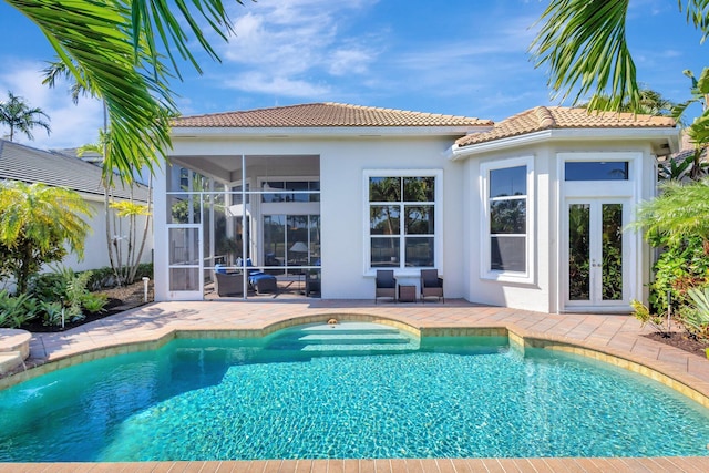 pool featuring a patio area, french doors, and a sunroom