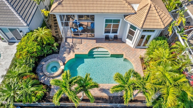 outdoor pool featuring an in ground hot tub, a patio area, and french doors