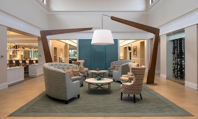 living area with a towering ceiling and wood finished floors