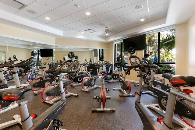 gym with a tray ceiling, recessed lighting, and a drop ceiling