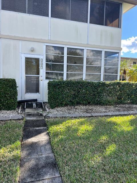 entrance to property featuring a yard