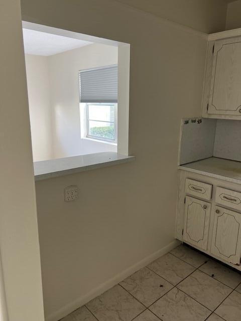 kitchen with light tile patterned flooring, light countertops, and baseboards