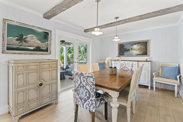 dining space featuring ornamental molding, beam ceiling, light wood finished floors, and wooden walls