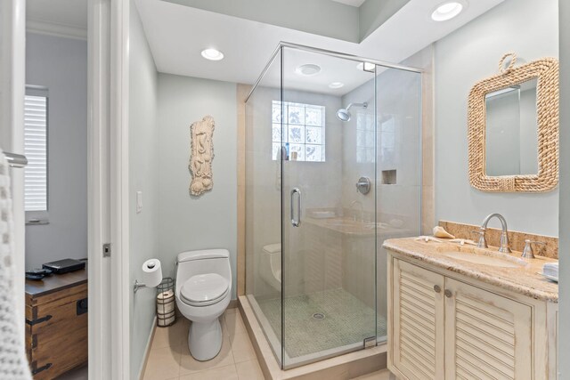 bathroom featuring tile patterned floors, vanity, a stall shower, and toilet
