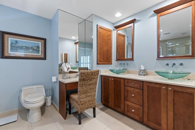 bathroom with toilet, double vanity, and a sink
