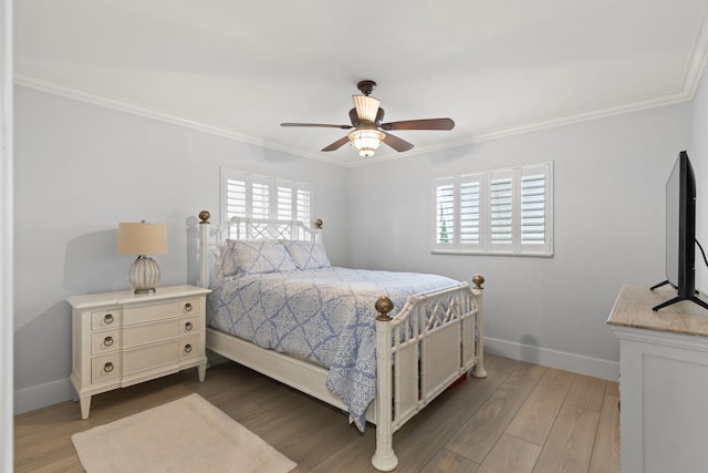 bedroom with crown molding, baseboards, multiple windows, and wood finished floors