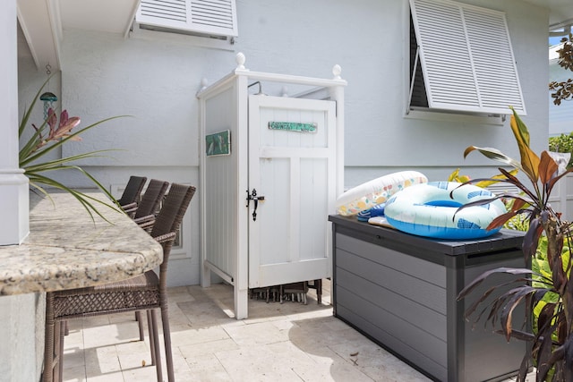 entrance to property featuring stucco siding and a wall mounted air conditioner