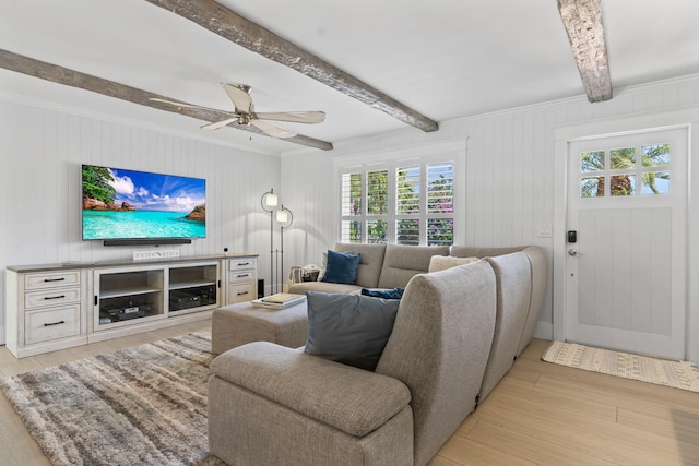 living area with light wood-type flooring, a ceiling fan, beam ceiling, and crown molding