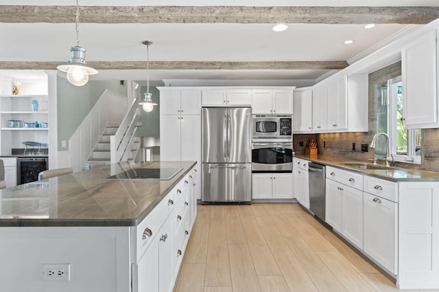 kitchen with a center island, a sink, light wood-type flooring, appliances with stainless steel finishes, and wine cooler