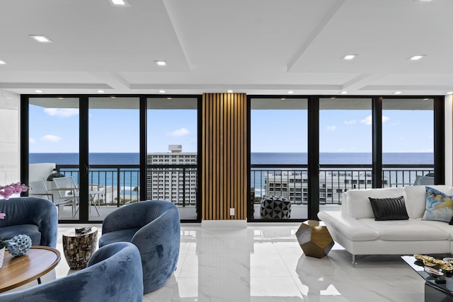 living area featuring recessed lighting, expansive windows, a water view, and marble finish floor