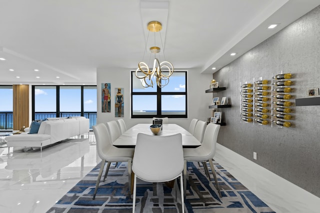 dining space with a notable chandelier, plenty of natural light, marble finish floor, and recessed lighting