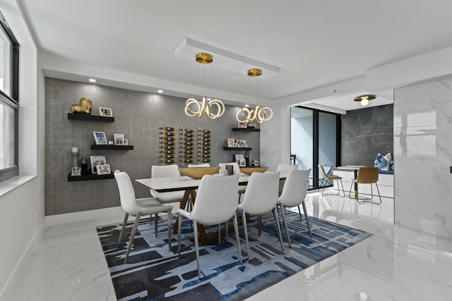 dining space featuring marble finish floor, recessed lighting, an inviting chandelier, baseboards, and stone wall