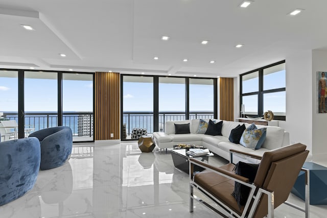 living room featuring marble finish floor, recessed lighting, a water view, and expansive windows