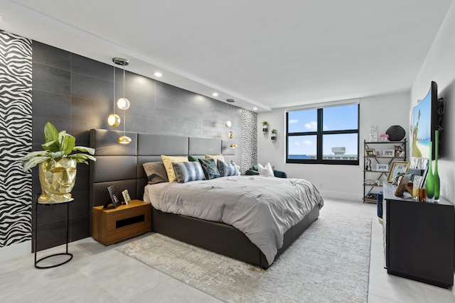 bedroom featuring light tile patterned floors, recessed lighting, and an accent wall