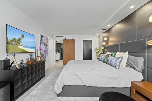 bedroom featuring a barn door, recessed lighting, and finished concrete flooring