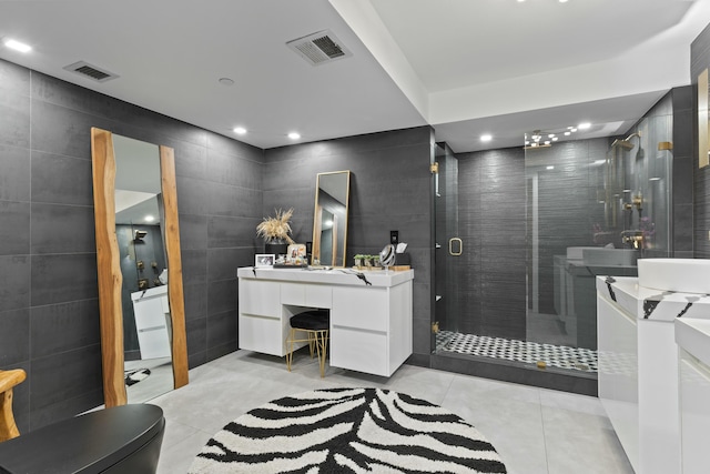 bathroom with visible vents, tile walls, a stall shower, and tile patterned flooring