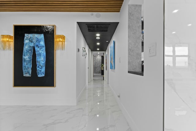 hall featuring visible vents, baseboards, and marble finish floor