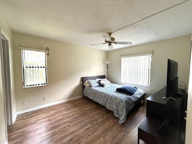 bedroom featuring a ceiling fan, wood finished floors, baseboards, and a textured ceiling