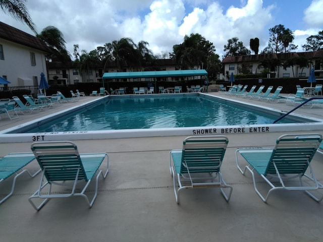 community pool featuring a patio area and fence