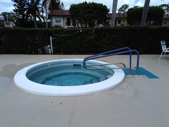 view of pool featuring a patio area, a community hot tub, and fence