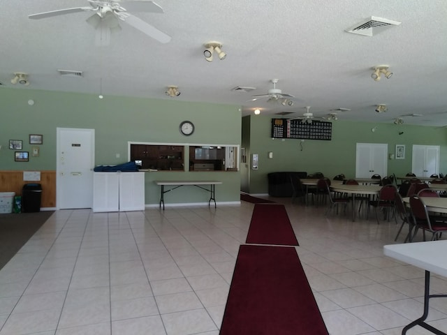 miscellaneous room with a textured ceiling, light tile patterned floors, visible vents, and ceiling fan