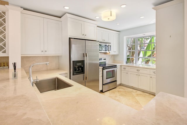 609 NE 19th Ave, Deerfield Beach, FL 33441 - kitchen with decorative backsplash, recessed lighting, white cabinets, stainless steel appliances, and a sink