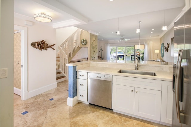 609 NE 19th Ave, Deerfield Beach, FL 33441 - kitchen with crown molding, light countertops, stainless steel appliances, white cabinetry, and a sink