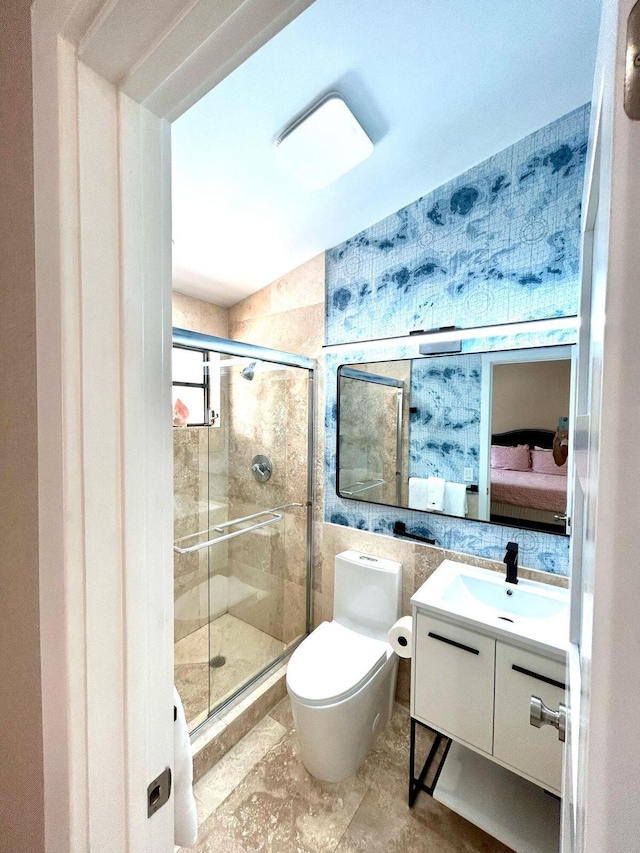 609 NE 19th Ave, Deerfield Beach, FL 33441 - bathroom featuring a shower stall, toilet, vanity, ensuite bathroom, and tile walls