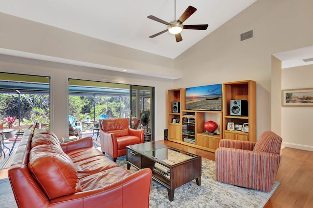 living area with a ceiling fan, baseboards, wood finished floors, visible vents, and high vaulted ceiling