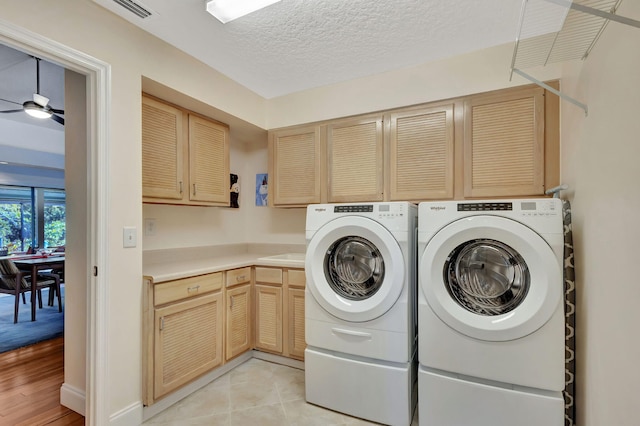 laundry area with visible vents, ceiling fan, cabinet space, a textured ceiling, and separate washer and dryer