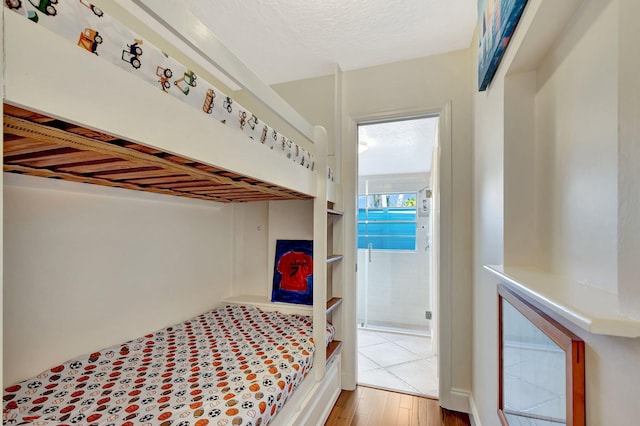 bedroom with wood finished floors and a textured ceiling