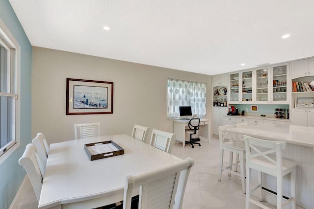 dining space with light tile patterned floors, recessed lighting, and indoor bar