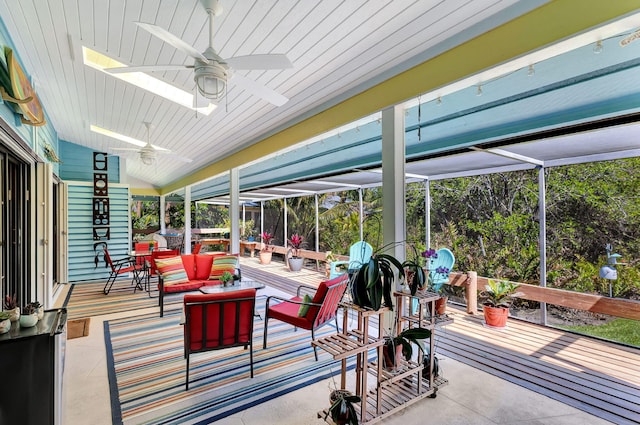 sunroom featuring vaulted ceiling with skylight and a ceiling fan