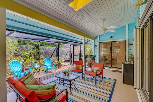 sunroom / solarium with lofted ceiling with skylight, wood ceiling, and a ceiling fan