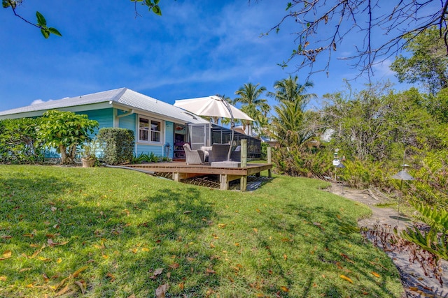 view of yard featuring a wooden deck and a lanai