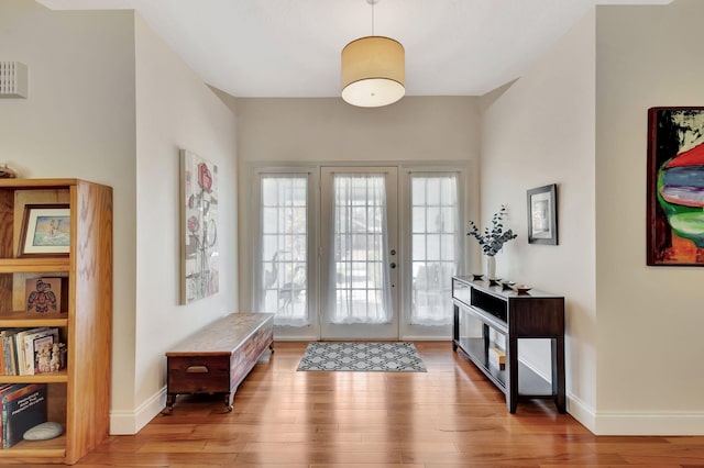 foyer with french doors, baseboards, and wood finished floors