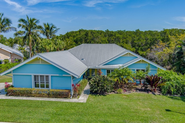 view of front of house featuring metal roof and a front yard