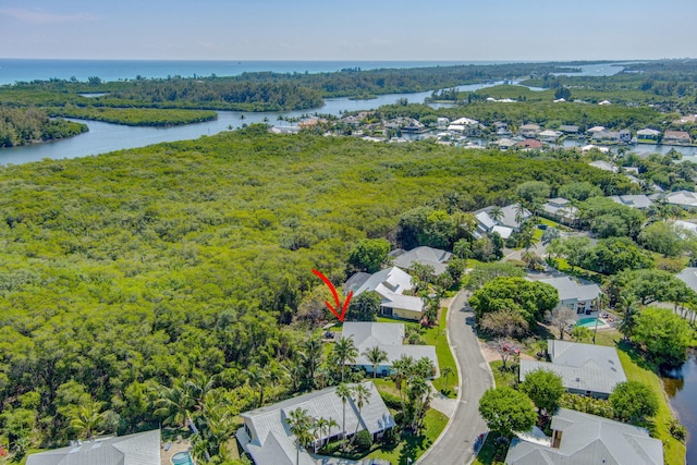 birds eye view of property with a residential view, a water view, and a view of trees