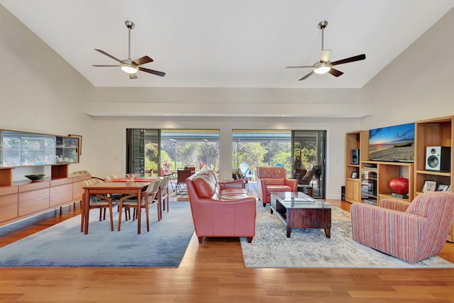 living room with wood finished floors, high vaulted ceiling, and ceiling fan