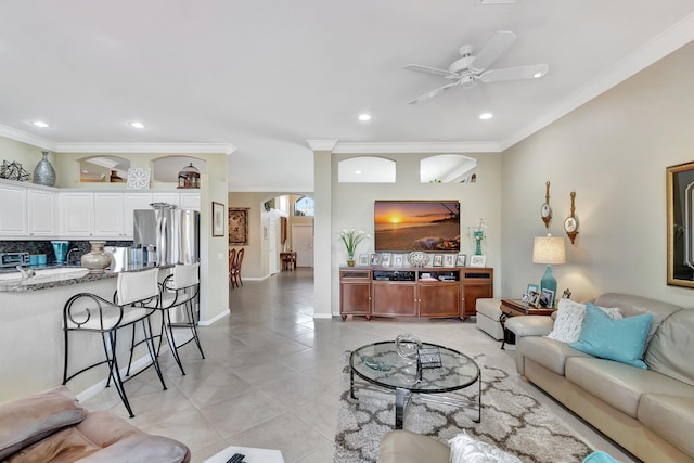 living room featuring a ceiling fan, light tile patterned flooring, recessed lighting, arched walkways, and ornamental molding