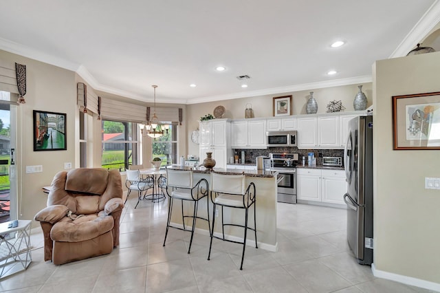 kitchen with tasteful backsplash, white cabinetry, stainless steel appliances, dark stone counters, and crown molding