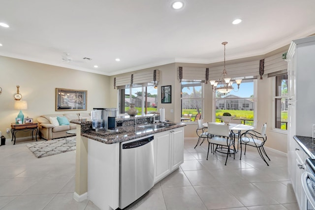 kitchen featuring crown molding, a chandelier, dark stone countertops, stainless steel dishwasher, and a sink