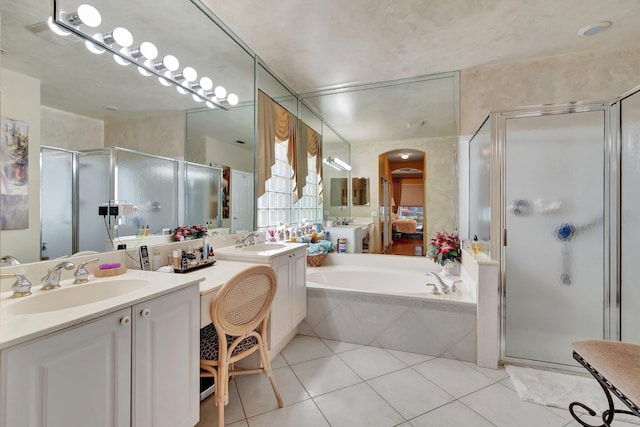 full bath featuring tile patterned floors, a stall shower, and a sink