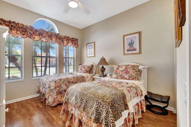 bedroom with baseboards, wood finished floors, and a ceiling fan